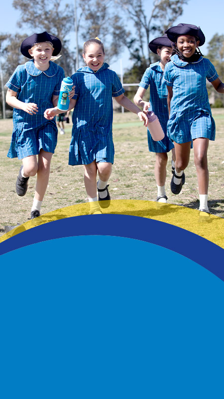 Students smiling together on the school oval at St Angela's Primary School Castle Hill