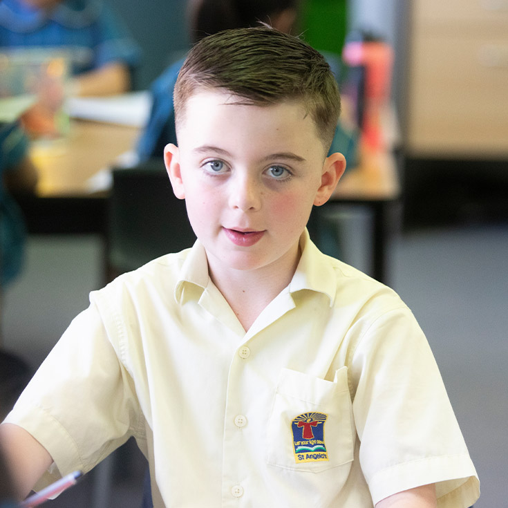 Student smiling in the classroom at St Angela's Primary School Castle Hill