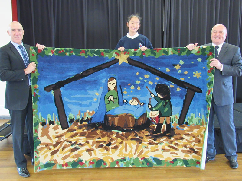 Kiara holding up her rug. David Elliott MP is standing opposite.
