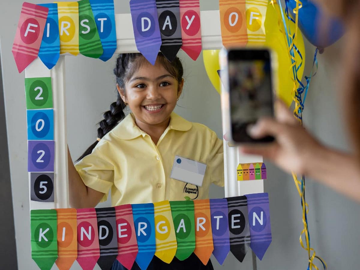 St Joseph's Kingswood Primary Kindergarten students holding banner that reads first day of Kindergarten