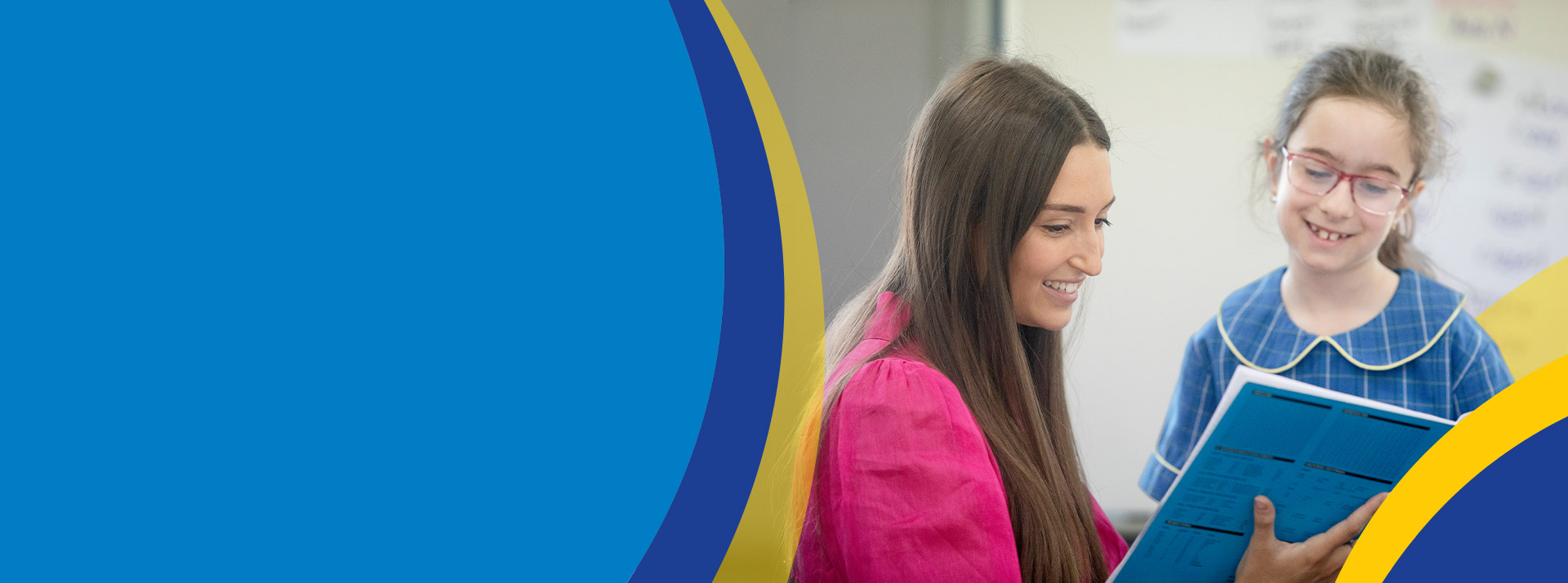 Teacher reading with her student in the classroom at St Angela's Primary School Castle Hill