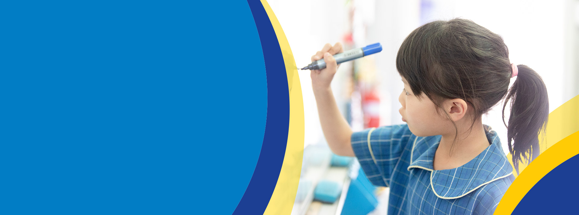 Student writing on a whiteboard in the classroom at St Angela's Primary School Castle Hill