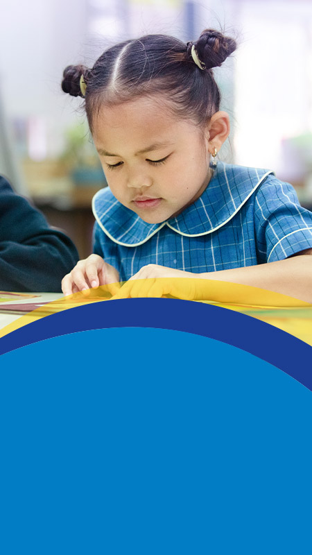 Student reading in the classroom at St Angela's Primary School Castle Hill