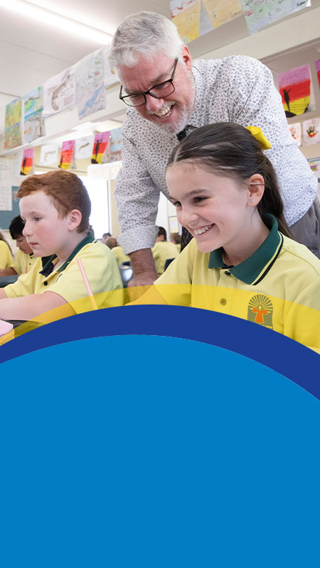 Teacher with his students in the classroom at St Angela's Primary School Castle Hill