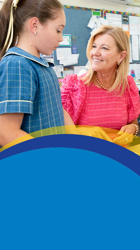 Teacher with her student in the classroom at St Angela's Primary School Castle Hill