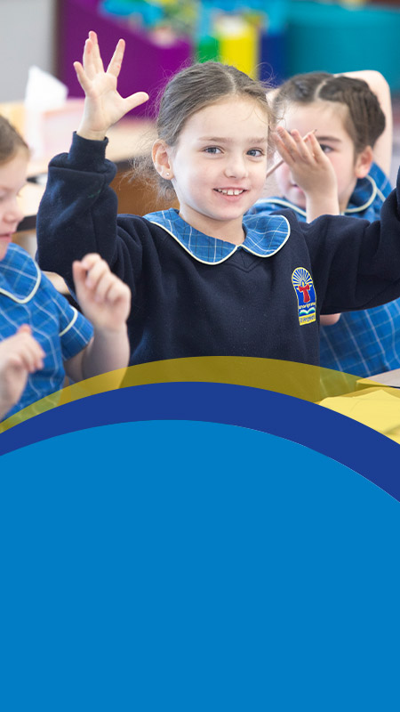 Student holding her hands up in the classroom at St Angela's Primary School Castle Hill