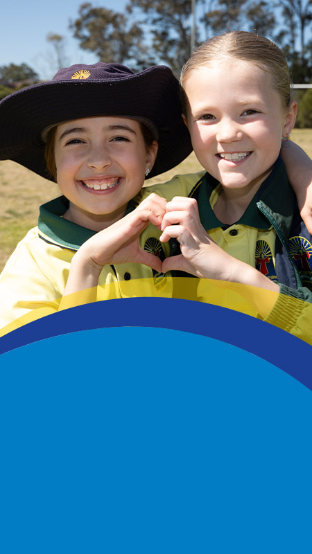 Students holding their fingers together to make a heart at St Angela's Primary School Castle Hill