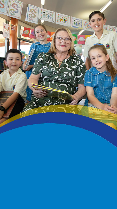 Principal Leanne Nettleton reading with students in the library at St Angela's Primary School Castle Hill