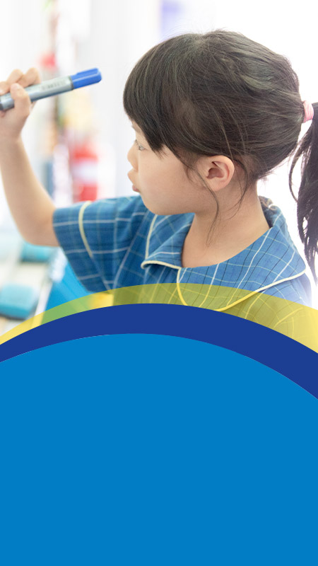 Student writing on a whiteboard in the classroom at St Angela's Primary School Castle Hill