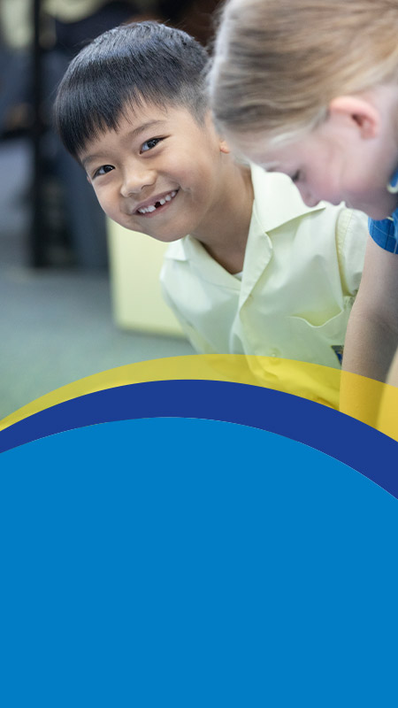 Student smiling in the classroom at St Angela's Primary School Castle Hill