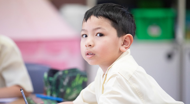 Student smiling in the classroom at St Angela's Primary School Castle Hill