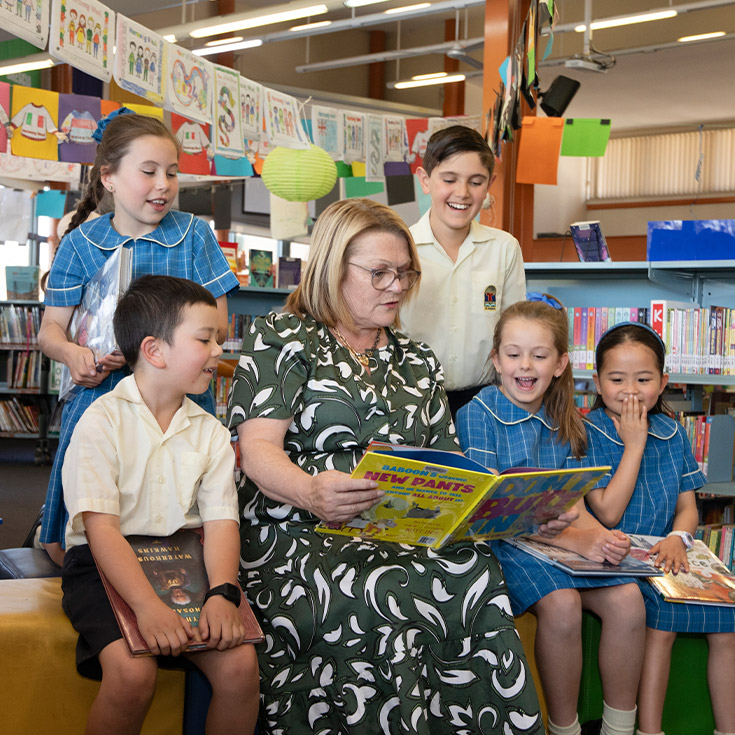 School principal Leanne Nettleton reading with students in the library at St Angela's Primary School Castle Hill
