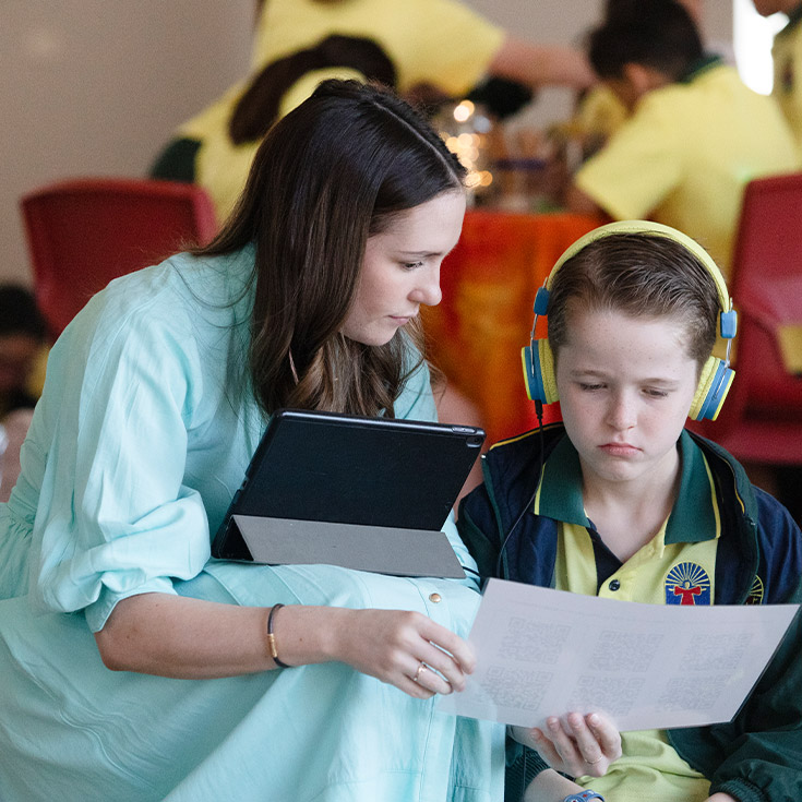 Teacher with her student in the classroom at St Angela's Primary School Castle Hill